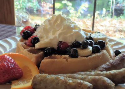 Delicious Crystal Cove waffles with fruit and sausage for breakfast